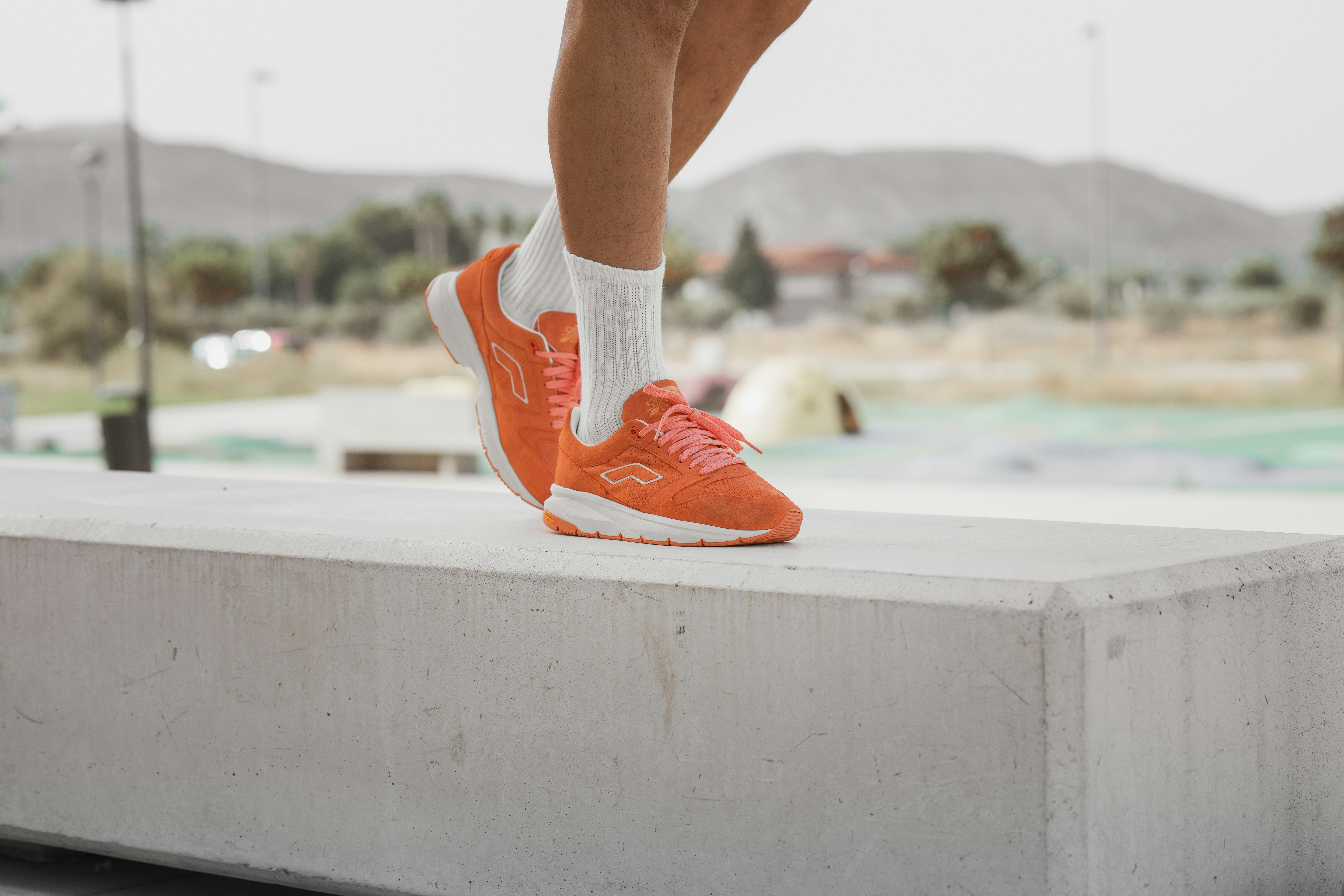 person in orange and white nike sneakers